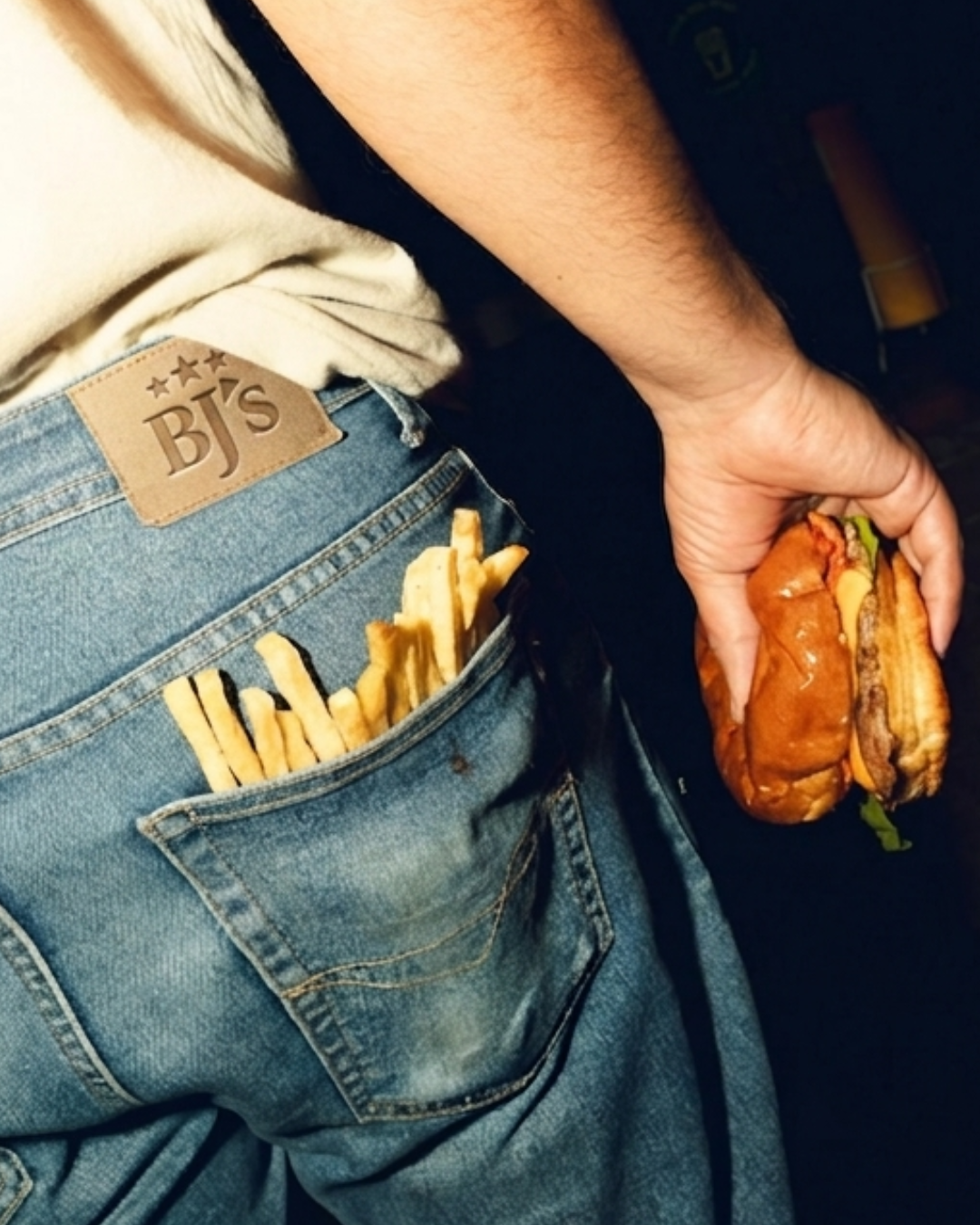 BJ's jeans pocket with fries and burger in hand